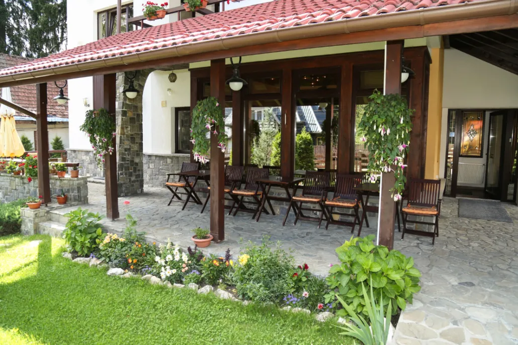 Casă cu acoperiș din țiglă și verandă din lemn